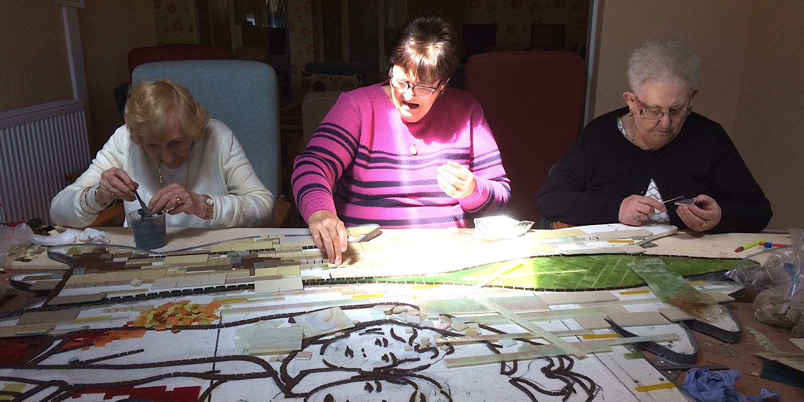 3 ladies in a row making a mosaic