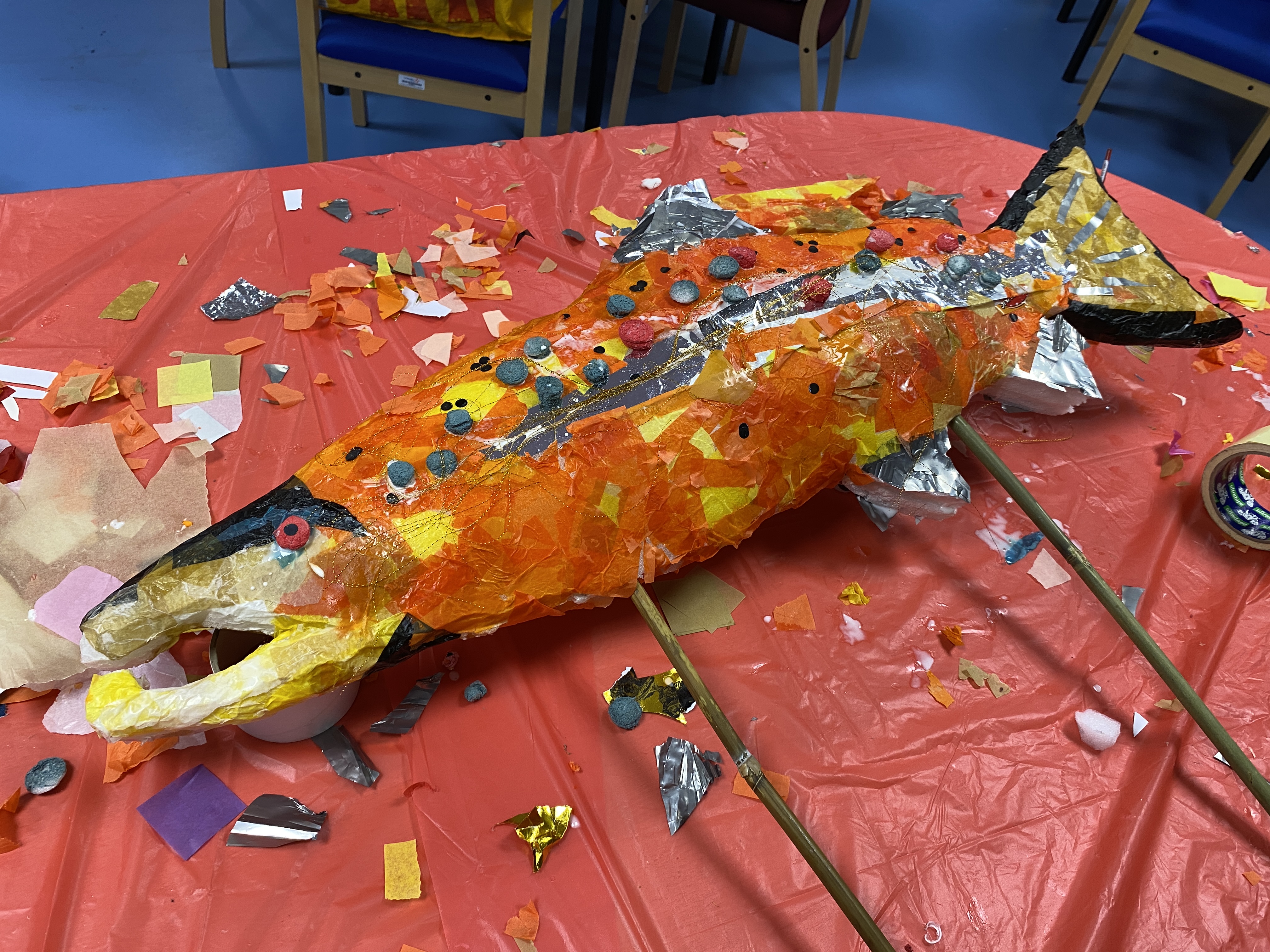 salmon puppet made of waste materials