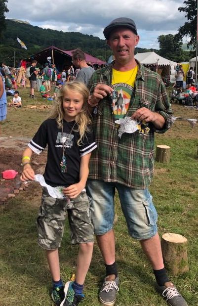Father and son at Greenman Festival showing the Street Fairy pendants they wear to support being Safe