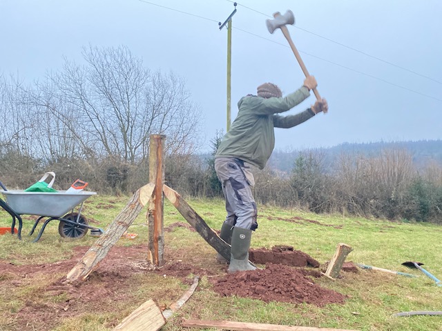 man hitting a post with a mallet